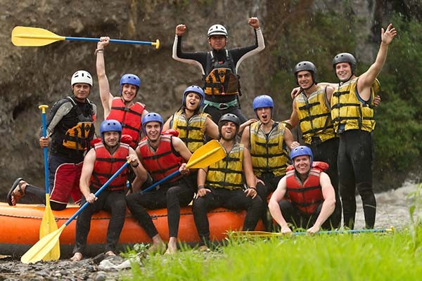Diverse group laughing while rafting through canyon